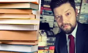 Stos książek obok autora. Ile Remigiusz Mróz napisał książek? Na półce widać tytuły: "Halny", "Precedens", "Rzniw", "Mroz".