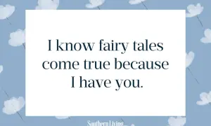 Niebieskie tło z białymi kwiatami i cytatem "I know fairy tales come true because I have you.