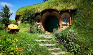 Zielone drzwi i okrągłe okna w zboczu wzgórza, gdzie mieszkał Bilbo Baggins. Obok wielka dynia na taczce.
