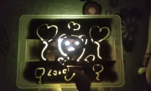 Napis "love" i misia z serduszkami na podświetlanej piaskownicy. Jak piękne smutne wiersze, które można wyczarować palcami.