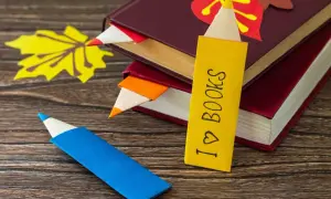 Jak zrobić ładną zakładkę do książki w kształcie kredki. Kolorowe zakładki wsuwają się między strony, a jedna z nich ma napis "I ♡ BOOKS".