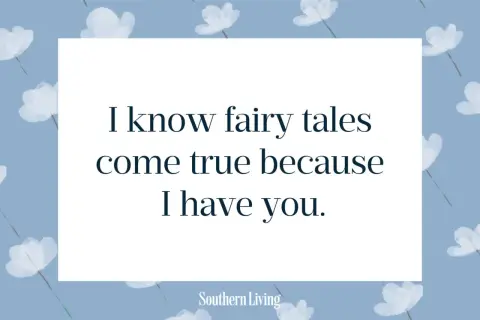 Niebieskie tło z białymi kwiatami i cytatem "I know fairy tales come true because I have you.