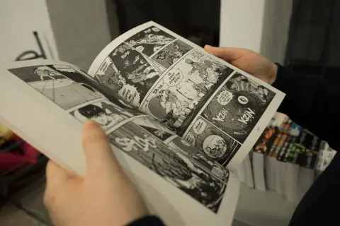 Osoba czyta mangę, dowodząc, że czy manga to utwór literacki. Dynamiczne panele i dymki dialogowe tworzą wciągającą historię.