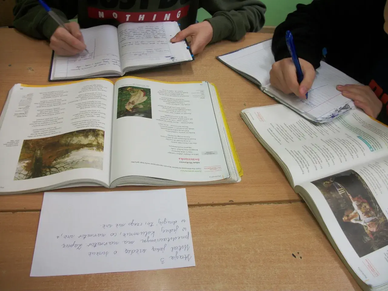 Dzieci piszą w zeszytach, obok leżą otwarte książki z wierszem "Świtezianka". To lekcja polskiego, gdzie analizują, dlaczego Świtezianka jest balladą.