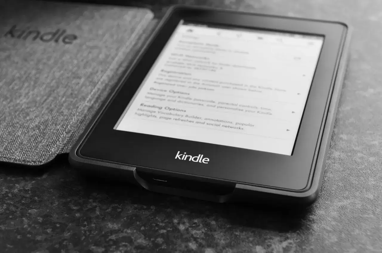 Kindle z okładką, ekran pokazuje opcje czytania. Dowiedz się, jak kupić książkę na Kindle.