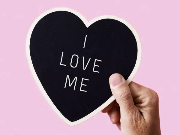 Dłoń trzyma serce z napisem "I LOVE ME". To jak piękne krótkie wiersze o miłości, zaczynające się od siebie.