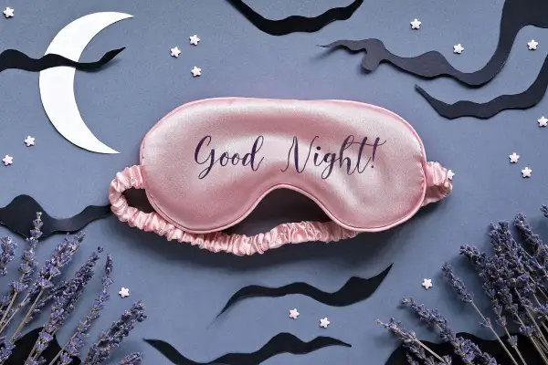 Różowa opaska na oczy z napisem "Good Night!" otoczona nocnymi elementami: księżycem, chmurami, gwiazdkami i lawendą. To piękny wiersz na dobranoc.
