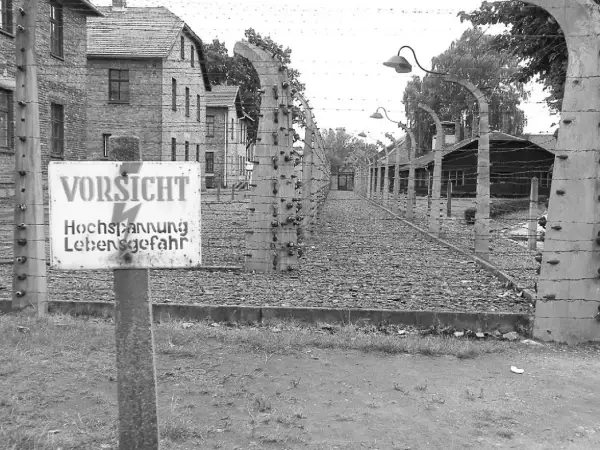 Znak "VORSICHT Hochspannung Lebensgefahr" przy ogrodzeniu z drutu kolczastego. Czy opowiadania Borowskiego to literatura faktu?